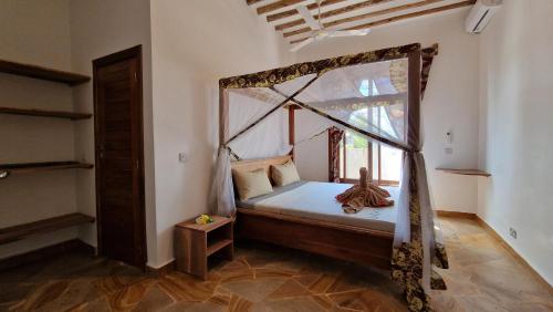 um quarto com uma cama de dossel e uma janela em Bantu Home em Paje