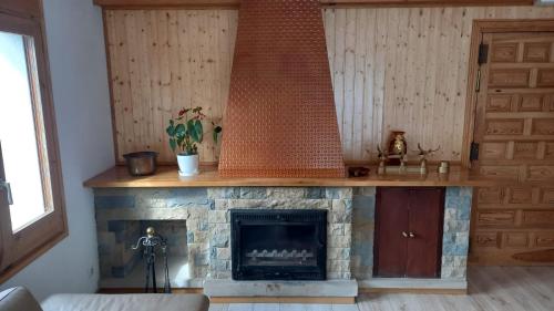 sala de estar con chimenea de piedra y manto de madera en Casa Rural Aliberch en Muntanyola