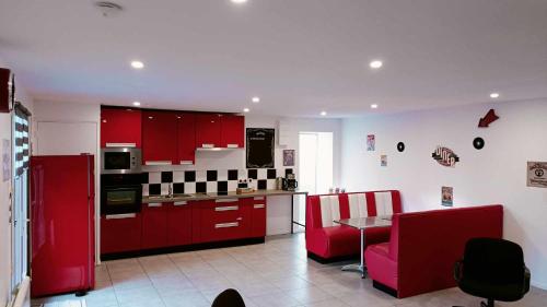 a kitchen with red cabinets and a table and chairs at GITE AMERICAN DINER sur la site THE FARM OUEST capacité 7 personnes in La Chaize-le-Vicomte