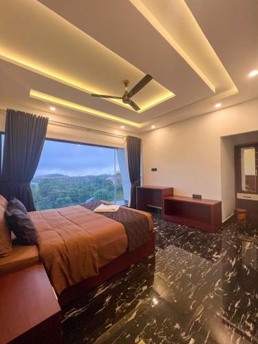 a hotel room with a bed and a large window at ADAM'S FORT by Dell'amore Havn in Vagamon