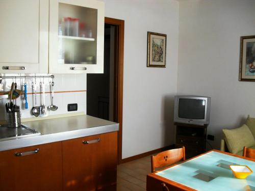a kitchen with a sink and a table and a tv at 8380 Miracolle apartments in Poggio Murella