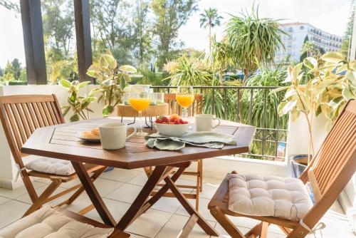 - une table en bois avec de la nourriture et des boissons sur un balcon dans l'établissement Charming and spacious apartment in Medina Garden - Puerto Banús, à Marbella