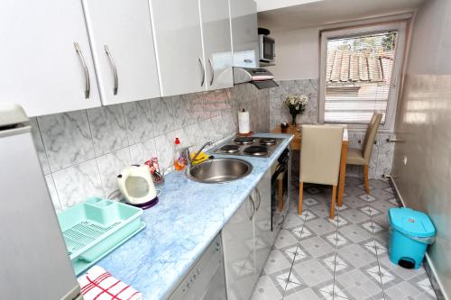a small kitchen with a sink and a table at Apartman Vrancic in Banja Luka