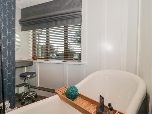 a white bath tub in a bathroom with a window at Athelney Cottage in Bridgwater