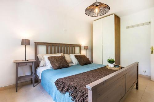 a bedroom with a large bed with a wooden headboard at La casa Escaniana in Cala Santanyi