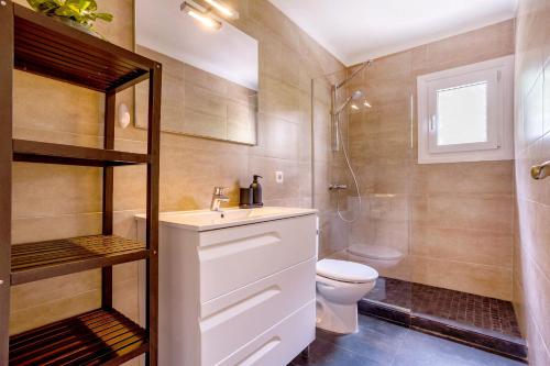 a bathroom with a toilet and a sink and a shower at La casa Escaniana in Cala Santanyi
