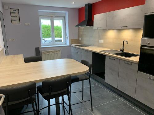a kitchen with a counter and a sink and a table at RELAIS ERMESINDE in Marville