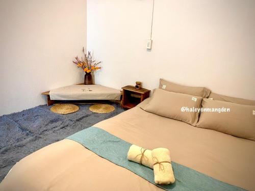 a bedroom with a bed and a table with a bench at Một Homestay Mang Den in Kon Von Kla