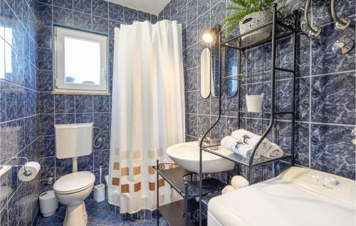 baño de azulejos azules con lavabo y aseo en Amazing Home In Bisko With Wifi, en Bisko
