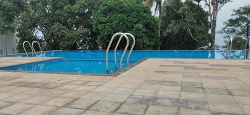a swimming pool with two metal chairs next to it at Winter Note Resorts in Munnar