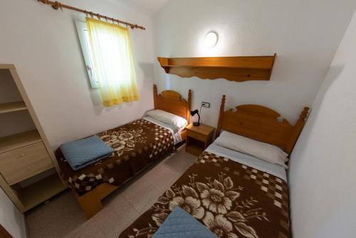 ein kleines Schlafzimmer mit 2 Betten und einem Fenster in der Unterkunft Bungalowpark Isábena in La Puebla de Roda