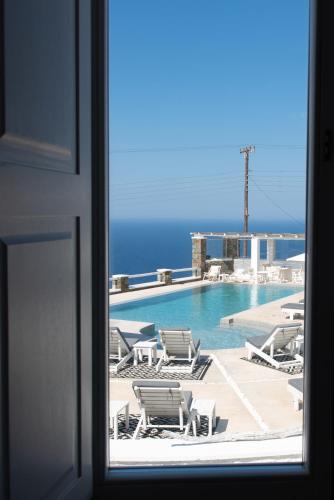 a view of a swimming pool from a window at Lemon Tree Houses in Ano Meria