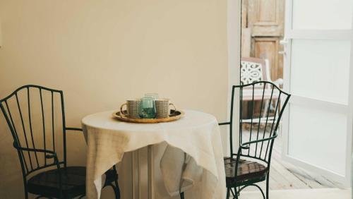 a table with a white table cloth and two chairs at Tzefania Hotel in Jerusalem