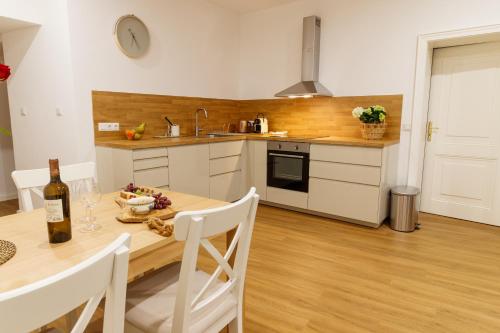 a kitchen with a table with a bottle of wine at Apartmany Tachov Garden House in Tachov