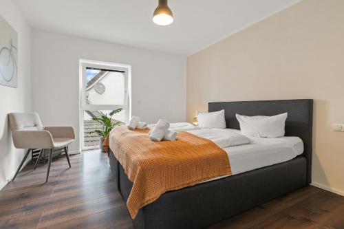 a bedroom with a large bed with an orange blanket at ma suite - Augsburg - Lechhausen in Augsburg