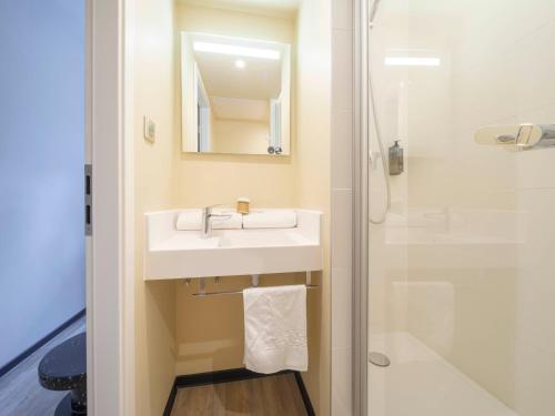 a bathroom with a sink and a shower at ibis budget Forbach Centre in Forbach
