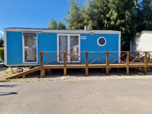 une petite maison bleue assise sur une terrasse en bois dans l'établissement Camping Costa Blanca, à El Campello