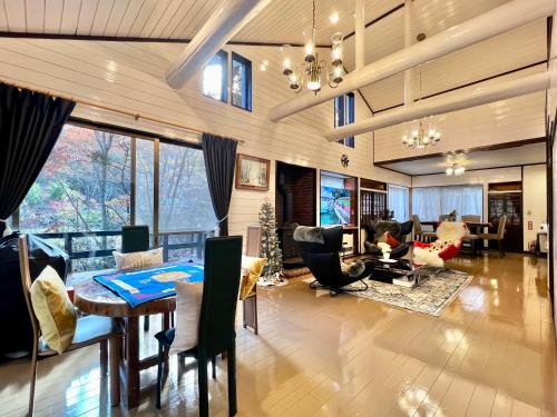 a large living room with a table and chairs at 虹の街22 #Nature Escape BBQ in Kita-karuizawa