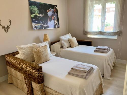 a room with two beds and a picture on the wall at Casa Palomera - Casa completa con jardín, gimnasio y garaje privados in León