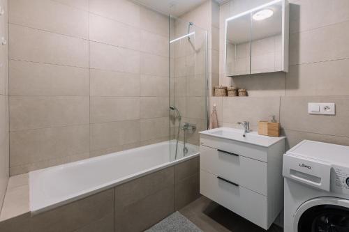 a bathroom with a tub and a sink and a shower at SKAU 1 Old Town Family & Business Apartment 1floor Free parking in Bratislava