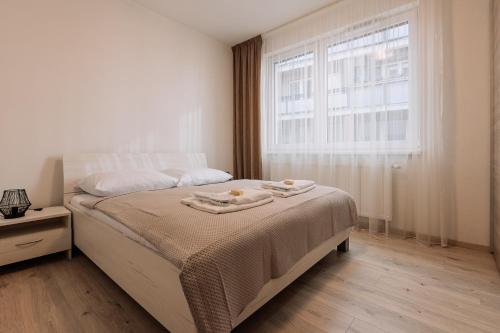 a bedroom with a bed with two towels on it at SKAU 1 Old Town Family & Business Apartment 1floor Free parking in Bratislava