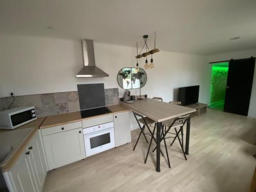 una cocina con una mesa y una encimera en Petite maison plain-pied climatisé, en Migné-Auxances