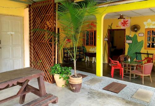 una casa con un portico con una pianta in vaso di THE COTTAGE LANGKAWI a Pantai Cenang
