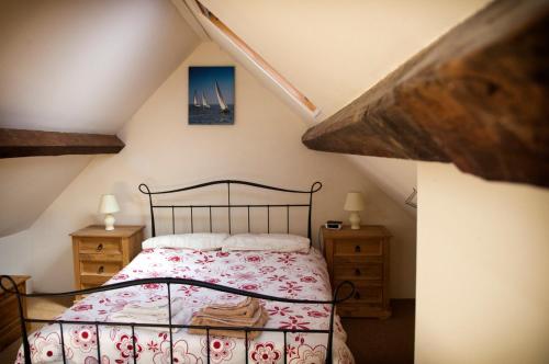 a attic bedroom with a bed and two dressers at RB Contractor Stays - Celyn in Pwllheli
