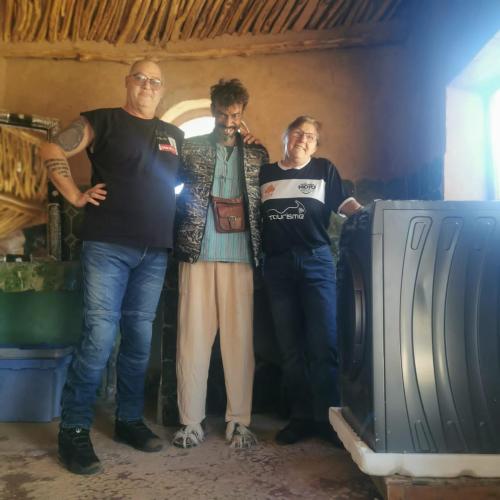 a group of three people standing next to a tv at Chez Madani in Mhamid