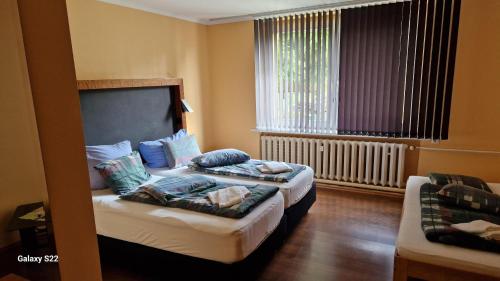 um quarto de hotel com duas camas e uma janela em Pension Stechlinsee em Neuglobsow