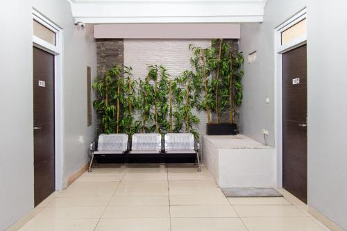 un corridoio con panche e piante in un edificio di OYO 657 Elite Residence Central Park Mall By TOS a Giacarta