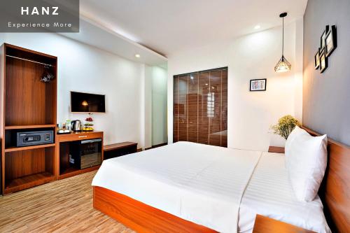 a bedroom with a large white bed and a tv at HANZ Ami Central Hanoi in Hanoi