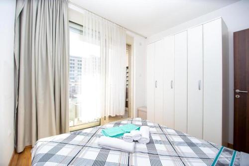 a bedroom with a bed with towels on it at Apartmans Budva centar in Budva