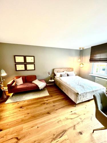 a bedroom with a bed and a couch at Premium Apartment an der Stadtmauer im OG in Paderborn