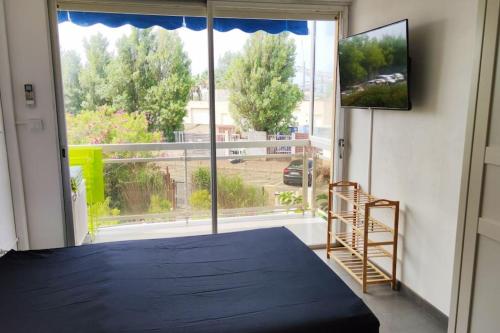 1 dormitorio con cama y ventana grande en Plages 130 m, parking privé, climatisé, wifi/fibre, en Valras-Plage