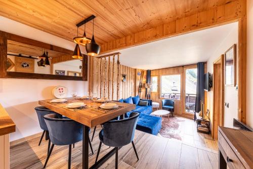 une salle à manger et un salon avec une table et des chaises dans l'établissement Le Blue Velvet - IMMODREAMS - Avoriaz, à Avoriaz