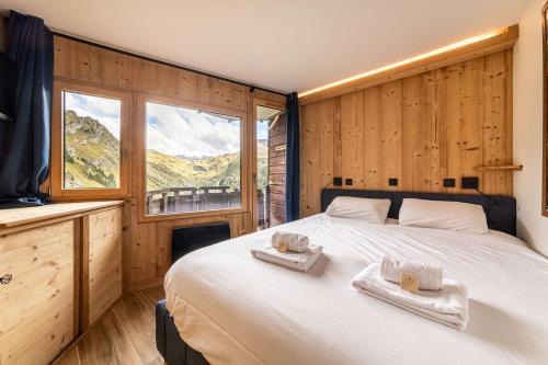 une chambre avec un lit avec deux serviettes dessus dans l'établissement Le Blue Velvet - IMMODREAMS - Avoriaz, à Avoriaz