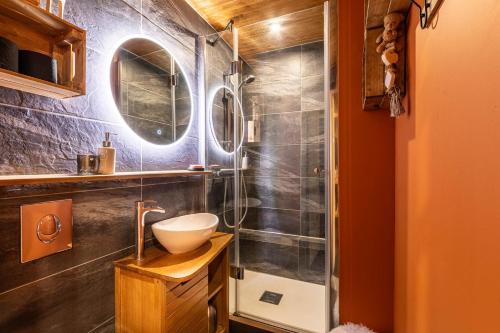 une salle de bain avec une douche avec un lavabo et un miroir dans l'établissement Le Bouquetin - IMMODREAMS - Avoriaz, à Avoriaz