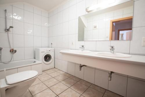 a bathroom with two sinks and a washing machine at Chalet Hochkrimml 141 in Krimml