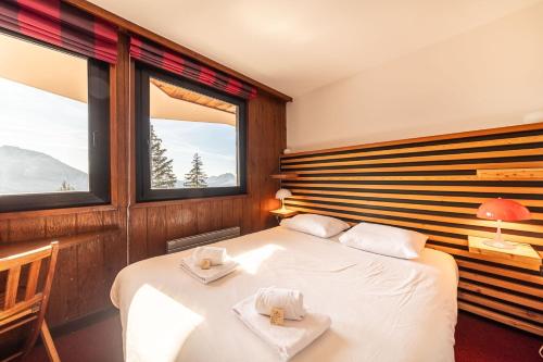 a bedroom with two beds and two windows at Le Sosna - IMMODREAMS - Avoriaz in Avoriaz