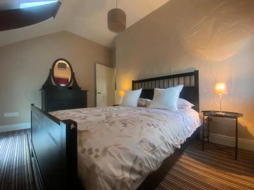 een slaapkamer met een groot bed en een spiegel bij Old Boathouse Upper Lough Erne 