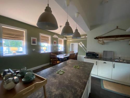 a kitchen with a table and a dining room at Old Boathouse Upper Lough Erne in Fairfield