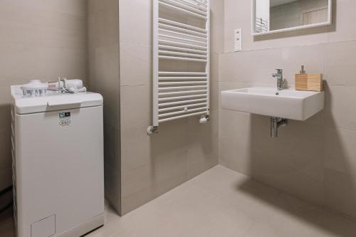 La salle de bains blanche est pourvue d'un lavabo et de toilettes. dans l'établissement SKAU Coral Residence in Sky Park 22 floor 1Tower Panoramic View Free Parking, à Bratislava