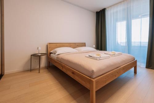 a bedroom with a bed with a large window at SKAU Sky Park Coral by Zaha Hadid 22 floor 1Tower Panoramic View Free Parking in Bratislava
