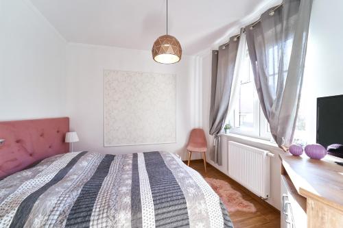 a bedroom with a bed and a desk and a television at LAGUNA Apartament 22 Willa Leśna in Polanica-Zdrój