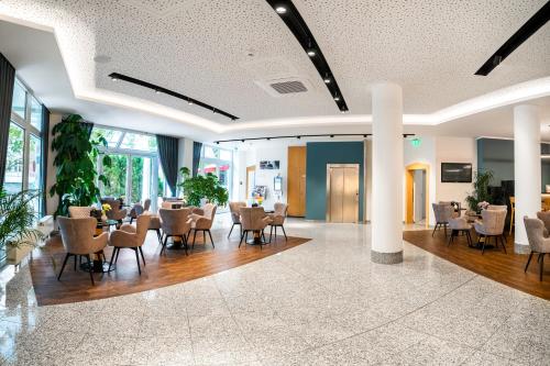 una hall con tavoli e sedie in un edificio di Andante Hotel Dresden a Dresda
