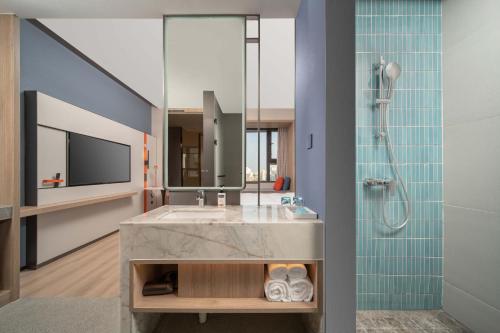 a bathroom with a sink and a shower at Holiday Inn Express Suzhou Shihu University Town in Suzhou