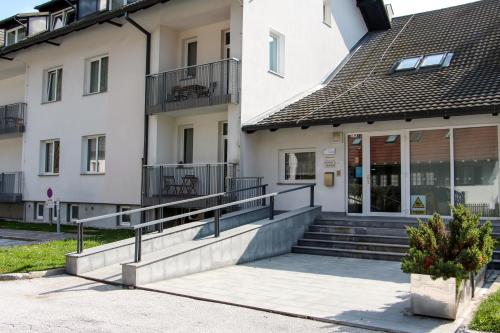 a white building with stairs and a balcony at Apartment Simona in Kranjska Gora