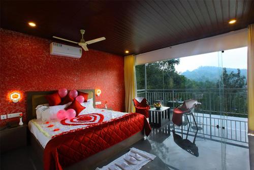 een slaapkamer met een bed met rode muren en een balkon bij zoz Idukki in Munnar