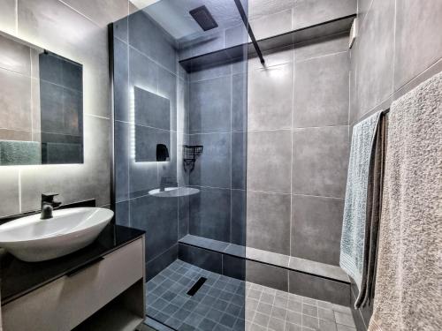 a bathroom with a sink and a mirror and a shower at Beautiful Chaka's Cove apartment in Ballito